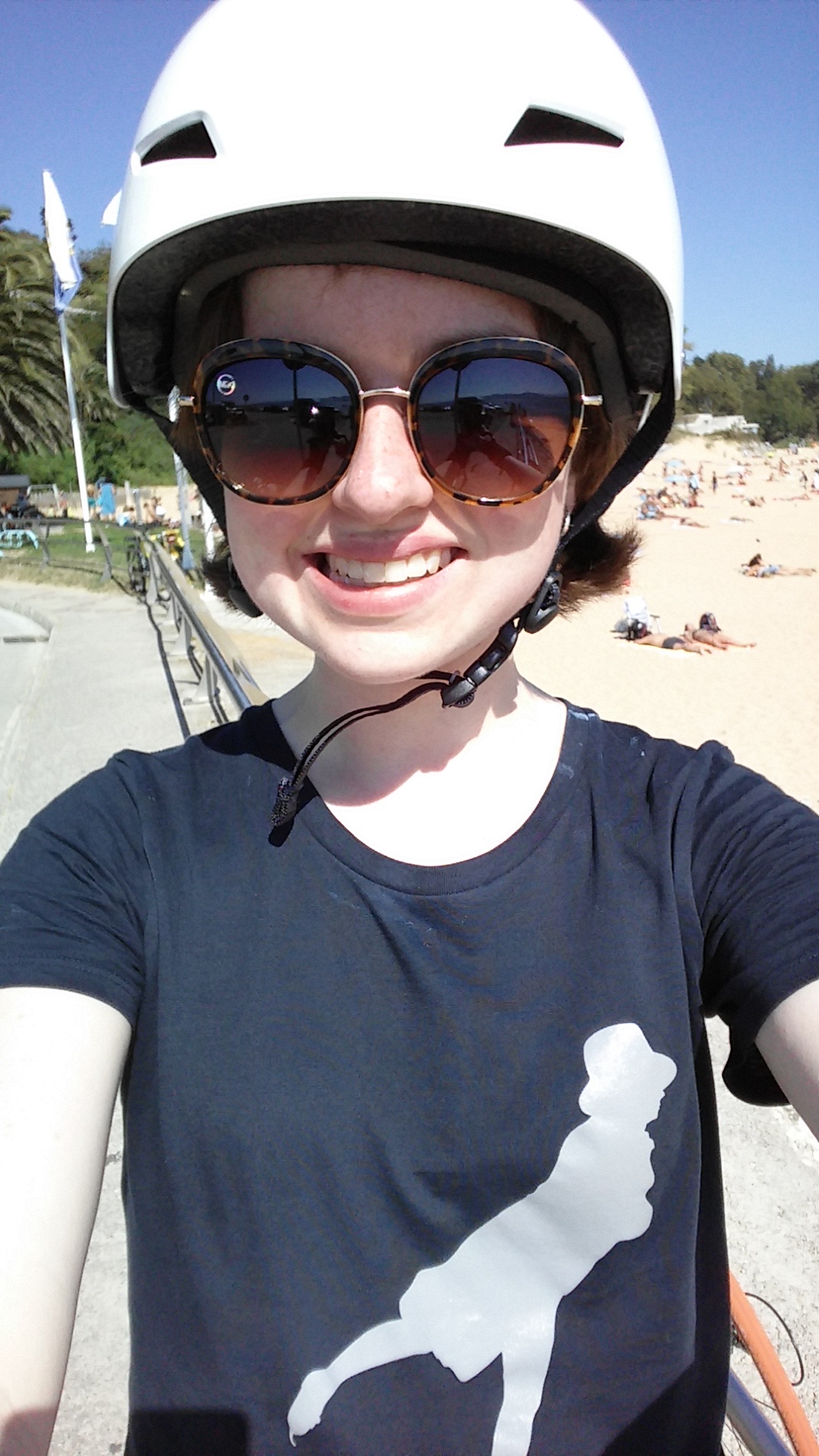 young caucasian female with a white skate helmet and a t-shirt with a picture of an ice skater on it